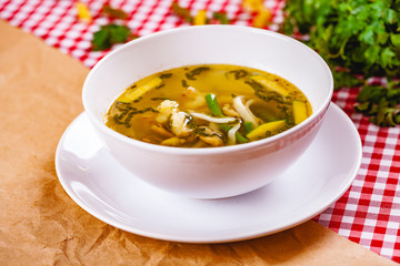 Soup with vegetables and seafood in white bowl. Close up