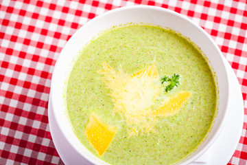 Broccoli cream soup with cheese in white bowl. Close up