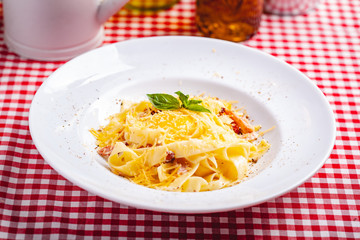 Italian cuisine. Pasta carbonara with bacon, cheese and egg on white plate. Close up
