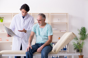 Obraz premium Old man visiting young male doctor 