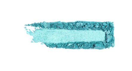 A broken green eye shadow smear, make up palette isolated on a white background. Top view, flat lay.