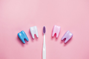 Toothbrush and big tooth on pink background. Teeth care minimalism concept. Copyspace for your text.