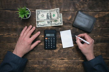 Business man is counting his last dollars from an empty wallet. Tight of money. Lack of money. Financial problems. Bankrupt. Pay the debts concept.