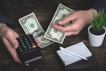 Business man is counting his last dollars from an empty wallet. Tight of money. Lack of money....