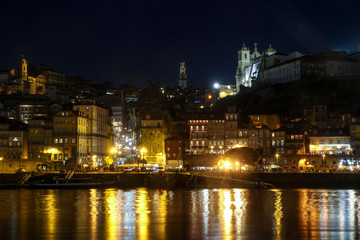 Fototapeta na wymiar night panorama of city centre skyline of porto, portugal with Clérigos Tower in centre and light reflections on douro river