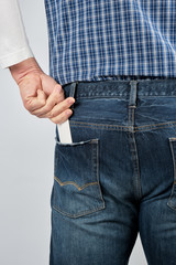 man puts an empty white paper business card in his back jeans pocket