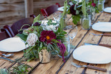 Table scape with dark red florals and wood accents