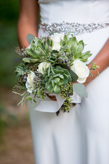 Bride holding a succulent bouquet on her wedding
