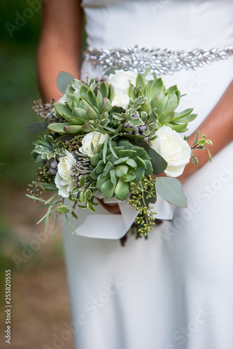 Bride holding a succulent bouquet on her wedding