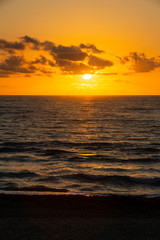 A golden sunrise with reflection on the Atlantic Ocean on Delray Beach, Florida.
