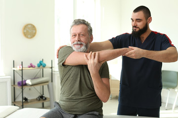 Physiotherapist working with patient in clinic. Rehabilitation therapy