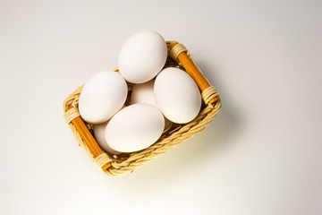 white chicken eggs in basket