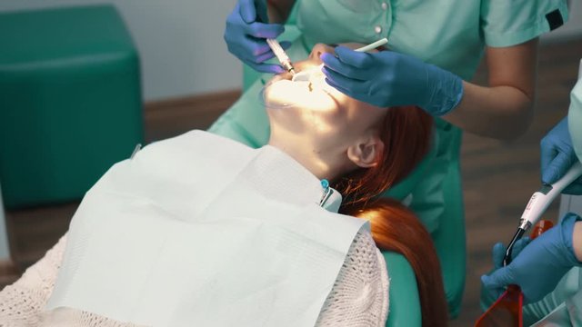 Applying insulating gel on gums and his photopolymerization lamp