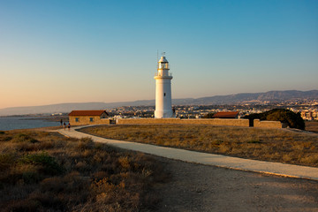 coast line with lighthouse, dune and rare vegetation in the background at sunset