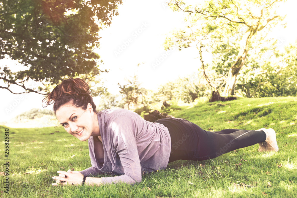 Wall mural Active young woman exercise outdoor at summer time