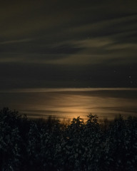 Moonset over snowy pines at night