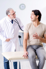 Obraz premium Young male patient visiting old doctor 