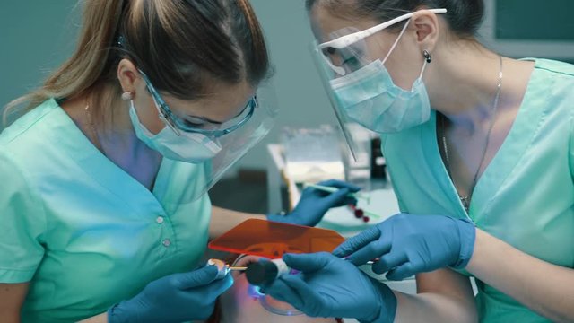 Applying insulating gel on gums and his photopolymerization lamp