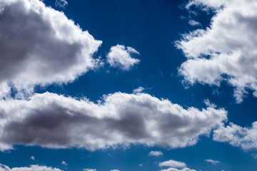 cloud formations in the shiny blue sky