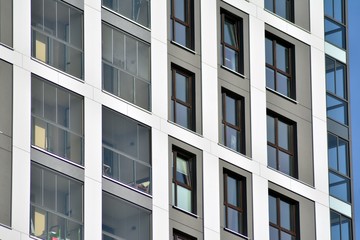 Multistory new modern apartment building. Stylish living block of flats. Modern, new executive apartments and with deep blue summer sky