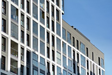 Multistory new modern apartment building. Stylish living block of flats. Modern, new executive apartments and with deep blue summer sky