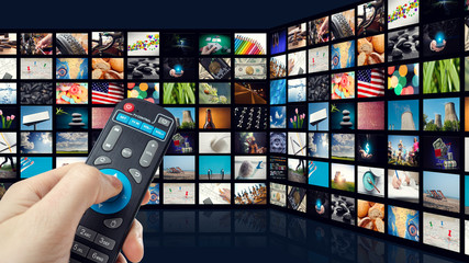 TV screen with lot of pictures and hands of man with remote control on blue background