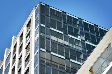 Multistory new modern apartment building. Stylish living block of flats. Modern, new executive apartments and with deep blue summer sky