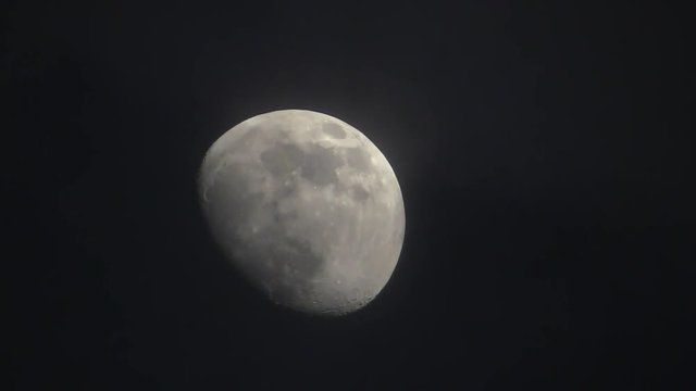 Moon in night sky. Clouds float along the moon