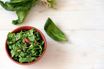Vegan spinach salad on a light wooden background