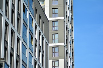Multistory new modern apartment building. Stylish living block of flats. Modern, new executive apartments and with deep blue summer sky