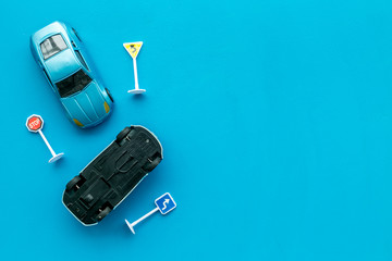 Car insurance concept with car toys on blue background top view copyspace