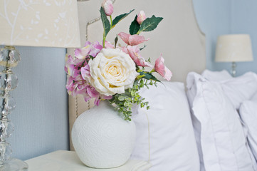 Vase of flowers, white rose. Bedside table, interior of a fashion house.