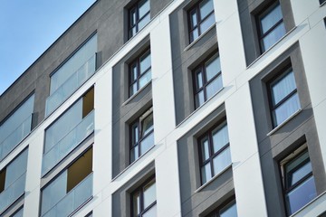 Multistory new modern apartment building. Stylish living block of flats. Modern, new executive apartments and with deep blue summer sky