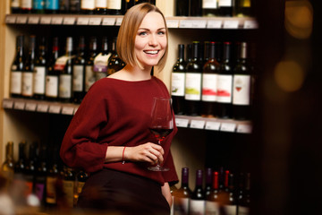 Picture of girl with glass in hands at store with wine