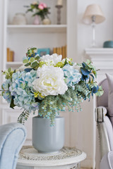 Vase of flowers on the table in the room. Stylish interior background.