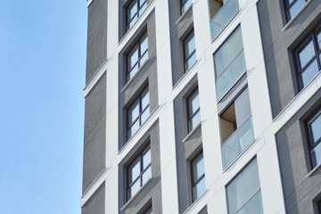 Multistory new modern apartment building. Stylish living block of flats. Modern, new executive apartments and with deep blue summer sky