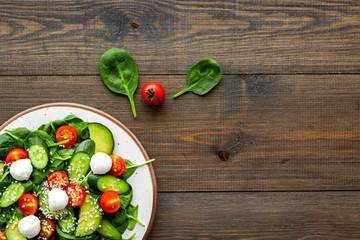 Vegetarian meal. Fresh vegetable salad on dark wooden background top view space for text