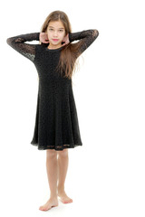 A little girl fixes her hair.