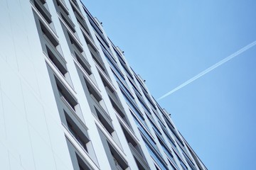 Multistory new modern apartment building. Stylish living block of flats. Modern, new executive apartments and with deep blue summer sky