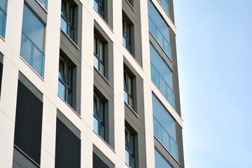 Multistory new modern apartment building. Stylish living block of flats. Modern, new executive apartments and with deep blue summer sky