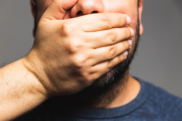 Fototapeta premium Close-up of a man hand covering his mouth - hand on mouth