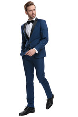 business man wearing a suit walking with hands in pocket