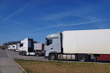 Fototapeta na wymiar Rest area for drivers. A row of trucks in the parking lot.