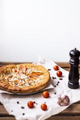 Pizza with bacon on the wooden table.Flat lay fast food. Traditional italian food. Pizza delivery from restaurant. Pizzeria menu. Tomatoes, pepper, cheese, bacon