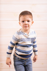 A boy of three years old posing in front of the camera on a white background