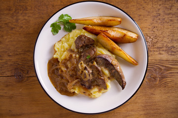 Liver with pears and cream and wine onion sause on mashed potato. overhead, horizontal