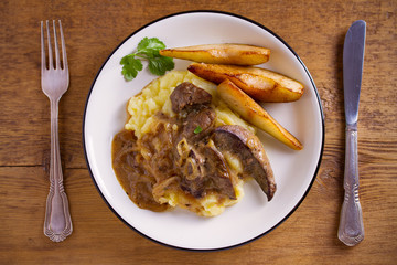 Liver with pears and cream and wine onion sause on mashed potato. overhead, horizontal