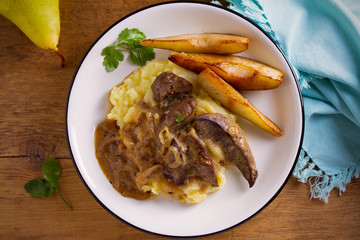 Liver with pears and cream and wine onion sause on mashed potato. overhead, horizontal