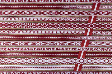 Latvian national style background with ornamented ribbons - obrazy, fototapety, plakaty