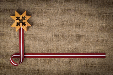 National composition of latvian flag ribbon and wooden symbol Auseklis - obrazy, fototapety, plakaty